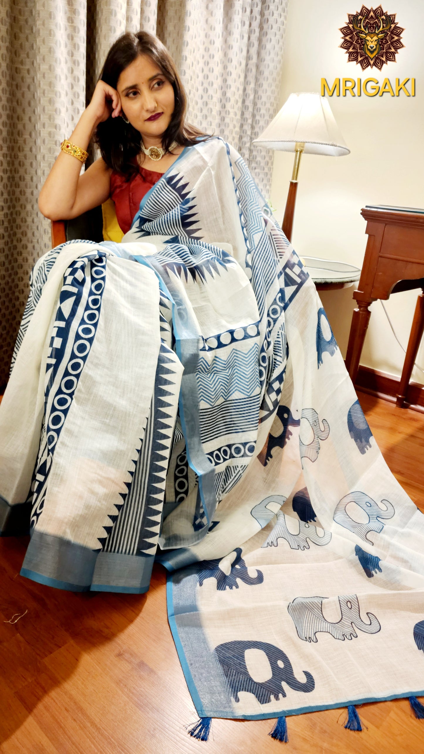 White Base Linen Saree with Geometrical design all over, turquoise blue elephant design border with Pom-Pom on Pallu