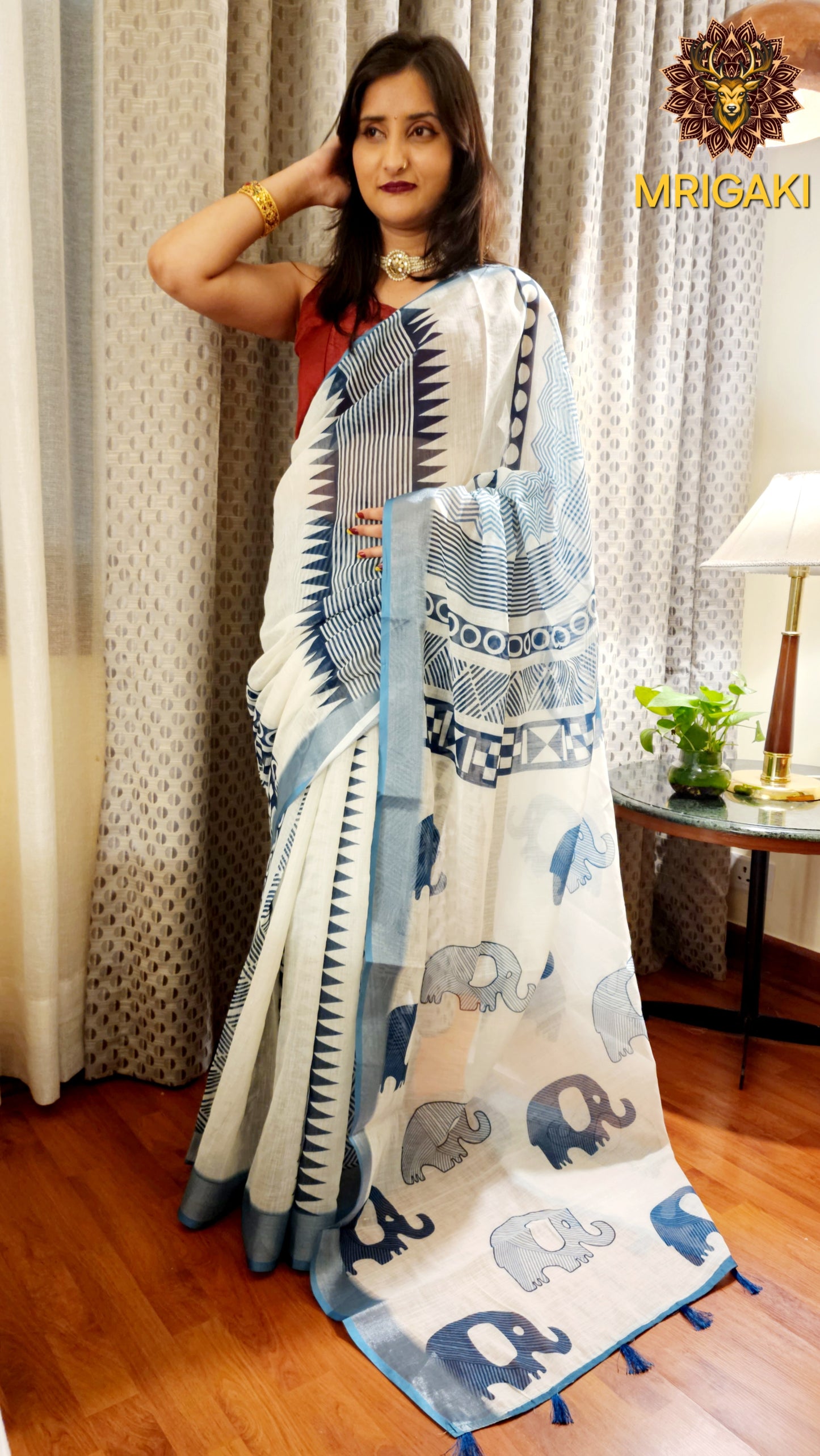White Base Linen Saree with Geometrical design all over, turquoise blue elephant design border with Pom-Pom on Pallu